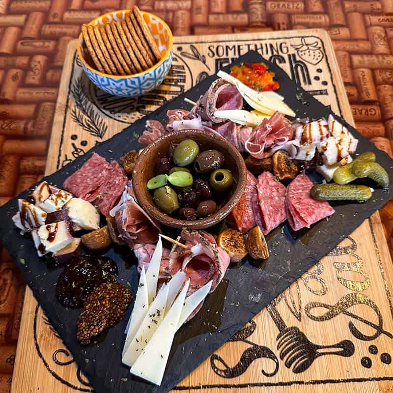Charcuterie board consisting of chef’s selection of meats, cheeses, and accoutrements