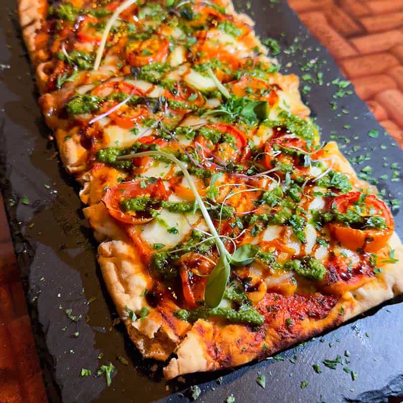 Margherita flatbread with roasted cherry tomatoes, mozzarella, basil, and a balsamic drizzle. Gluten-free option available
